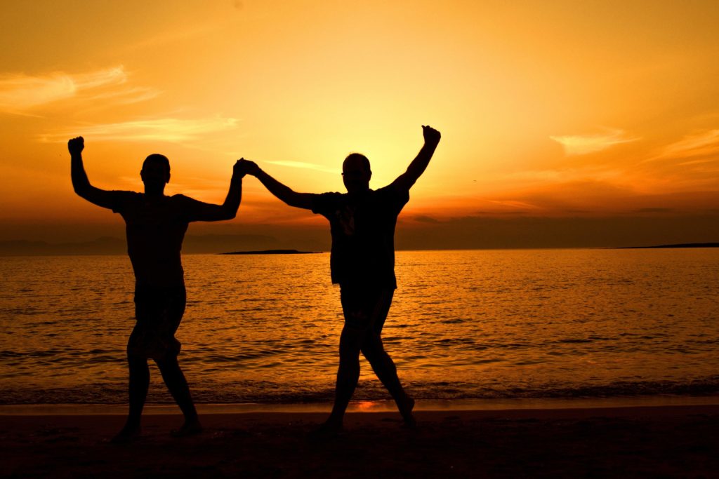 silhouette of people on the beach during sunset