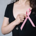 a photo of a person holding a pink ribbon