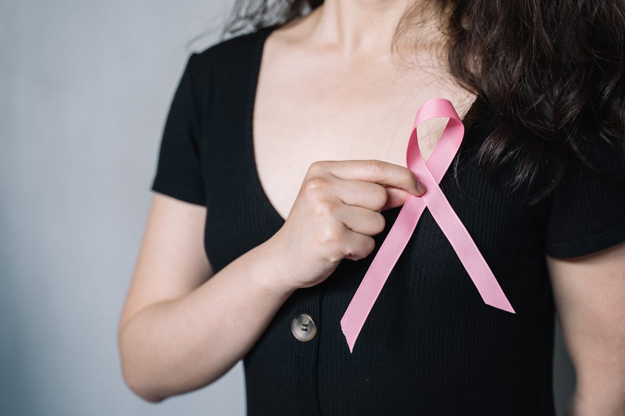 a photo of a person holding a pink ribbon