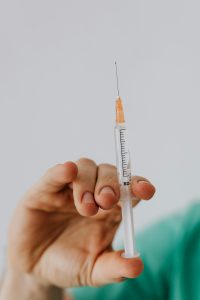 closeup photo of a nurse holding a vaccine