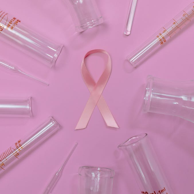 a pink ribbon surrounded by test tubes